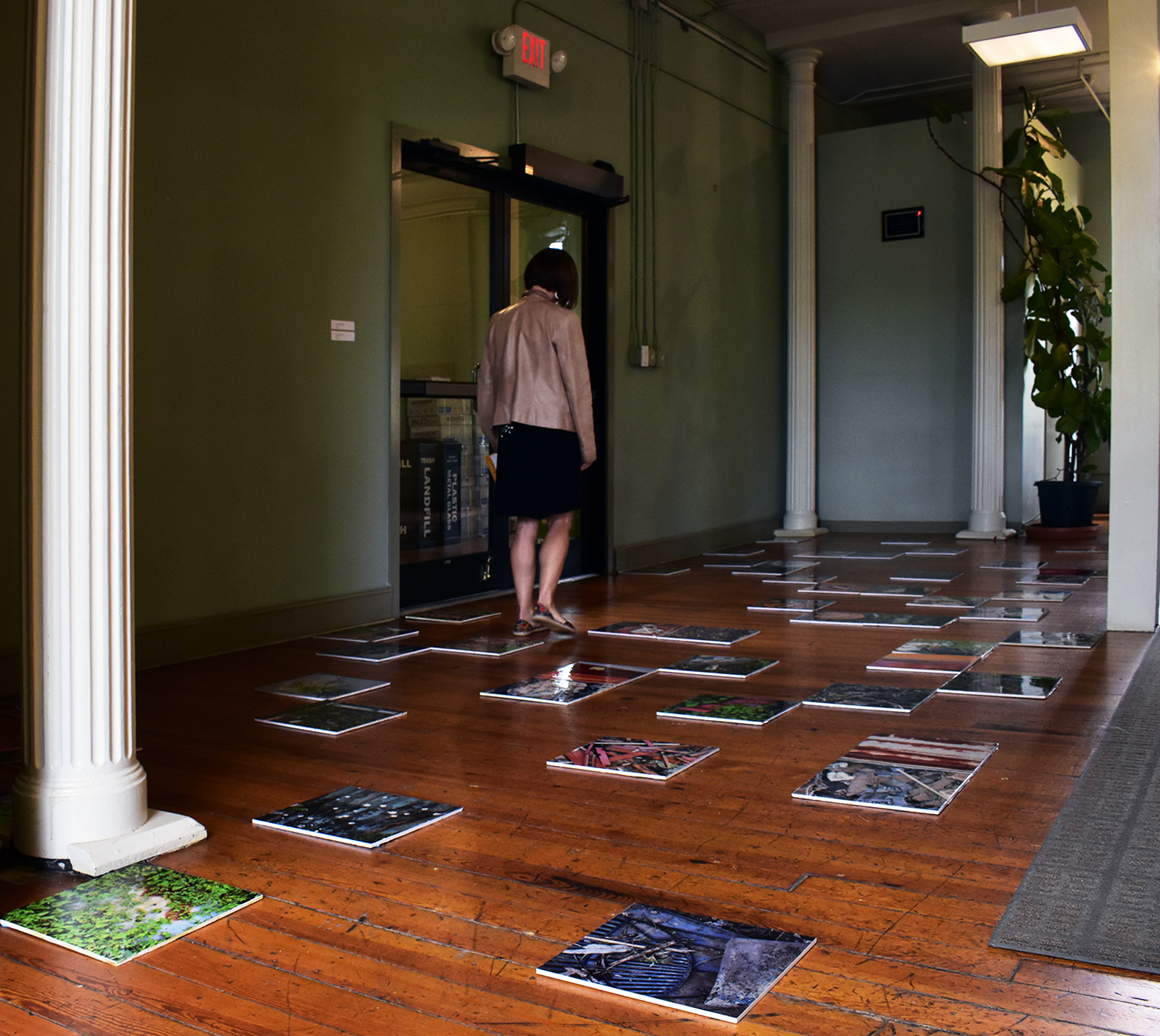Someone walks among the tiles of Groundscapes Displaced, showing how the piece invites interaction and draws the eye