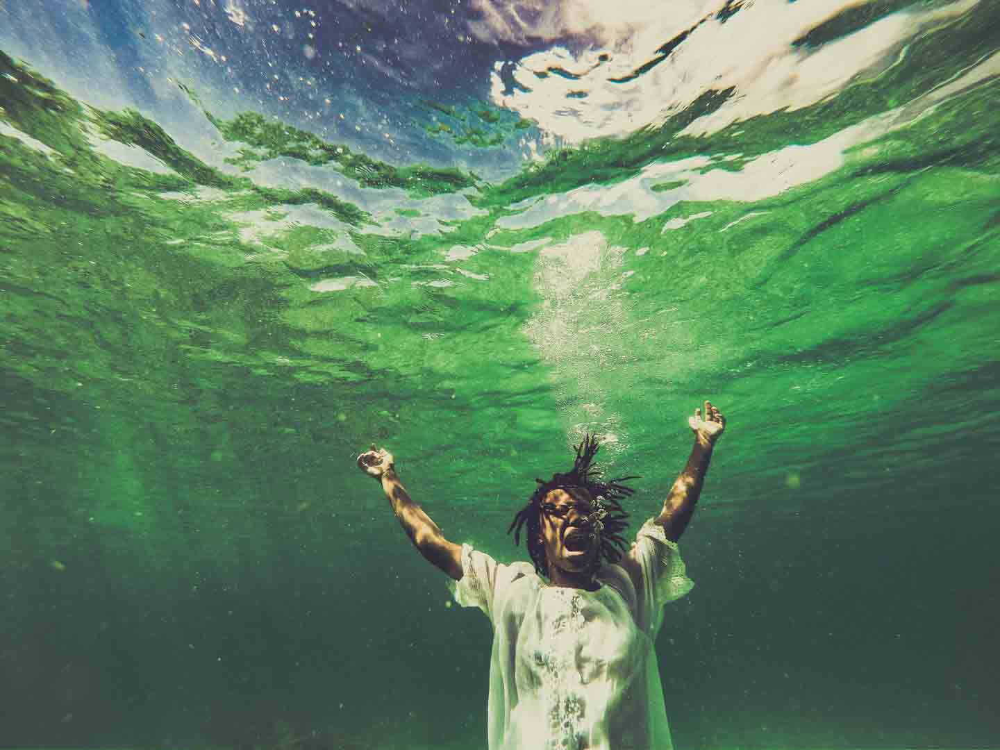 David Berg's 'Deafening Silence' shows a young Black woman underwater, posed as though screaming with her arms raised